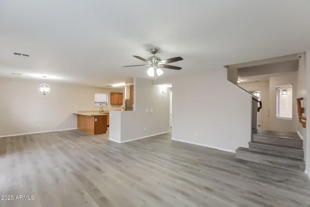 a view of a livingroom with wooden floor and a ceiling fan