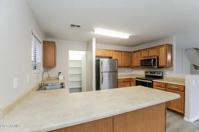 a kitchen with stainless steel appliances a refrigerator and a stove top oven