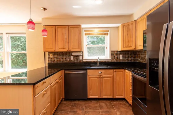 a kitchen with stainless steel appliances granite countertop a sink and a refrigerator
