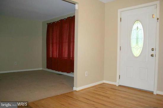 16613 Trenton Road Upperco, MD 21155 - Photo 8 of 15 an empty room with wooden floor and mirror