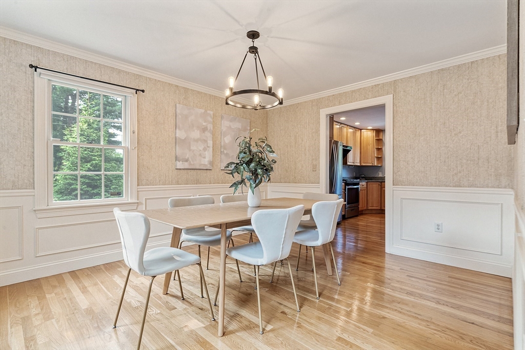 166 Forest Street Winchester, MA 01890 - Photo 5 of 37 a dining room with wooden floor a chandelier a glass table and chairs