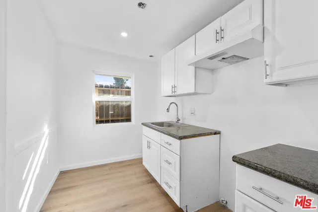 a kitchen with sink cabinets and a wooden floor