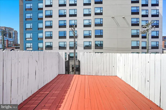 a view of a balcony with wooden floor and fence