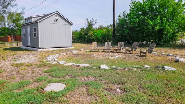 a view of backyard with a garden and fire pit