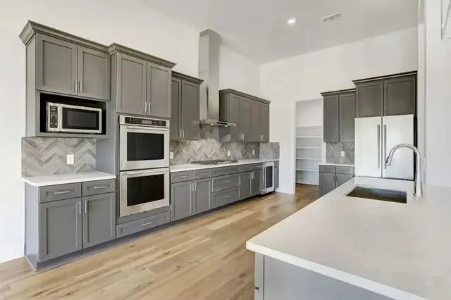 a kitchen with stainless steel appliances kitchen island granite countertop a stove a sink and a microwave