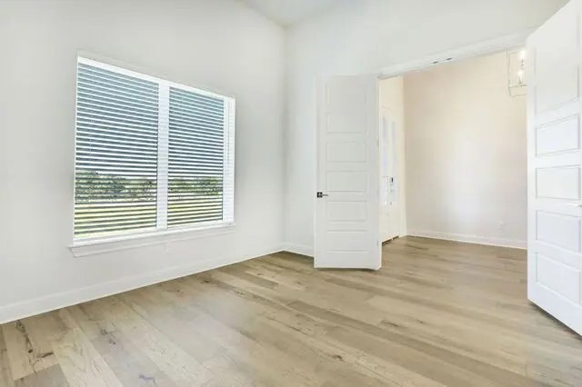 104 Lazy Oak Place Spicewood, TX 78669 - Photo 29 of 40 a view of an empty room with wooden floor and a window