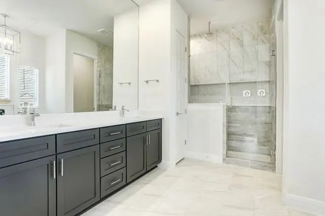 104 Lazy Oak Place Spicewood, TX 78669 - Photo 30 of 40 a bathroom with a double vanity sink and mirror