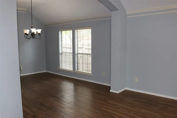 a very nice looking room with wooden floor and windows