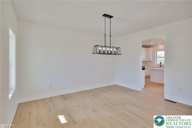 a kitchen with stainless steel appliances a sink a stove a refrigerator cabinets and a window