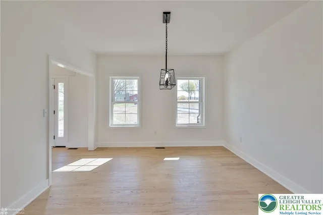 a view of an empty room with a fireplace and a window
