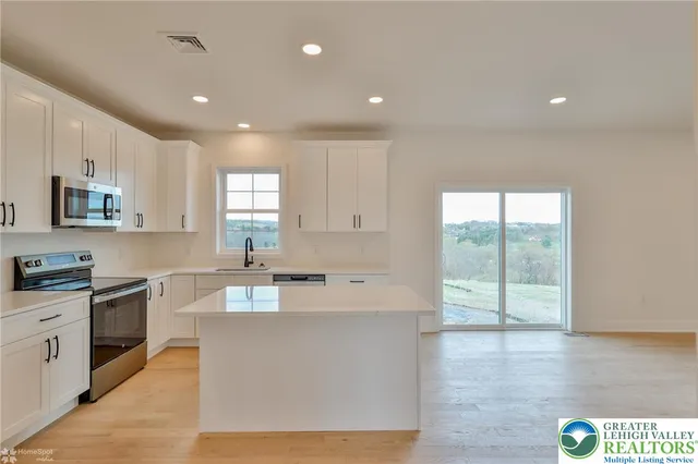 a view of an empty room with a window and a fireplace