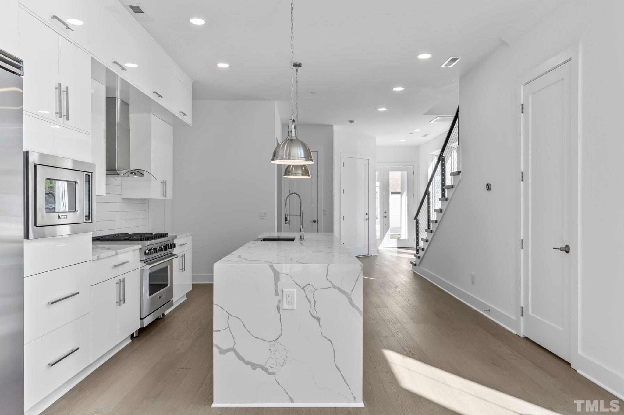 4009 Southpoint Landing Way, Unit 5 Durham, NC 27707 - Photo 11 of 43 a large kitchen with stainless steel appliances kitchen island granite countertop a large center island attached withe living room