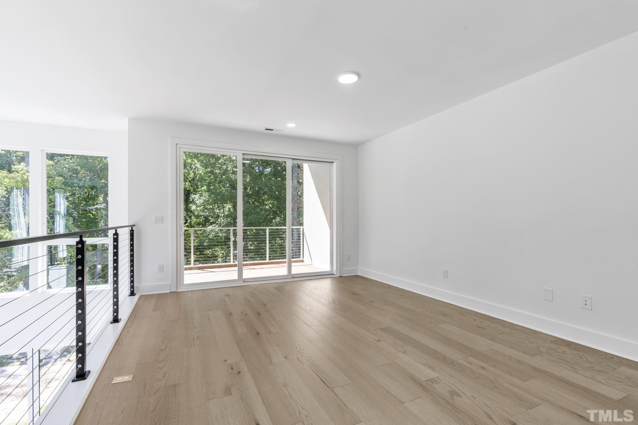 4009 Southpoint Landing Way, Unit 5 Durham, NC 27707 - Photo 16 of 43 a view of an empty room with wooden floor and a window
