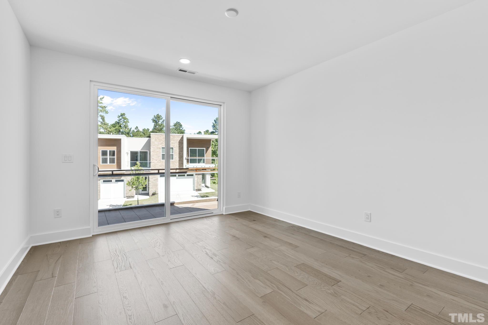 4009 Southpoint Landing Way, Unit 5 Durham, NC 27707 - Photo 27 of 43 an empty room with wooden floor and windows