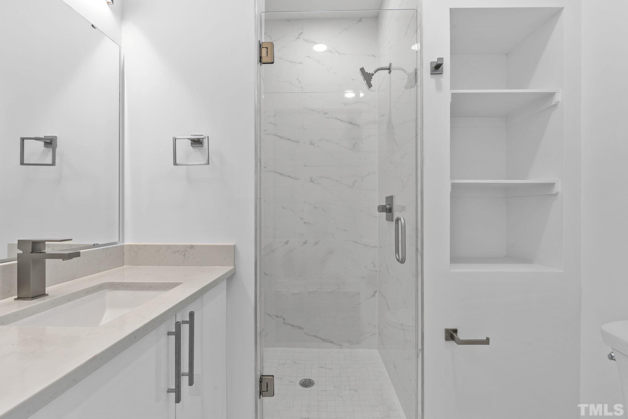 4009 Southpoint Landing Way, Unit 5 Durham, NC 27707 - Photo 32 of 43 a bathroom with a shower sink vanity and a mirror