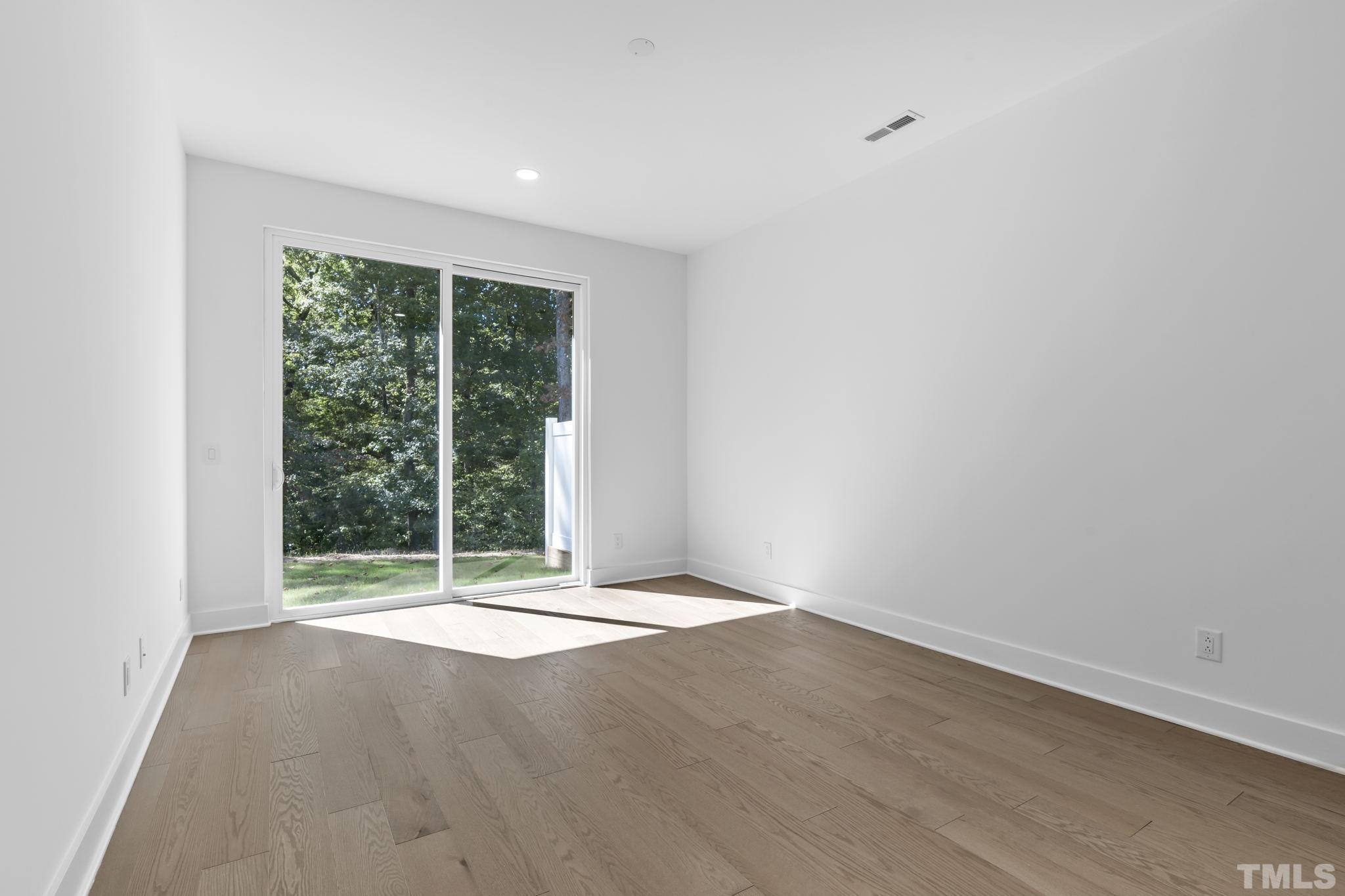 4009 Southpoint Landing Way, Unit 5 Durham, NC 27707 - Photo 7 of 43 an empty room with wooden floor and windows