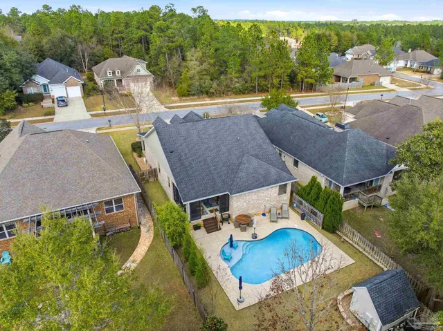 an aerial view of a house with swimming pool and outdoor seating