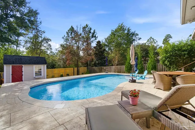 an aerial view of a house with outdoor space and swimming pool