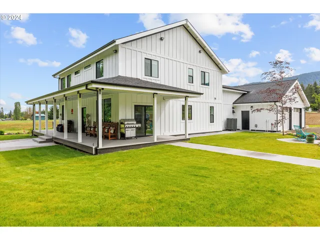 a view of a green yard with large trees