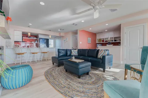 a living room with furniture and a view of kitchen
