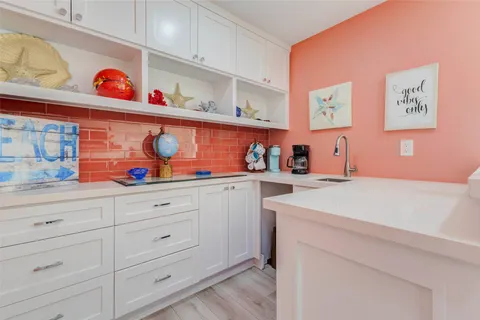 a utility room with stainless steel appliances cabinets and a window