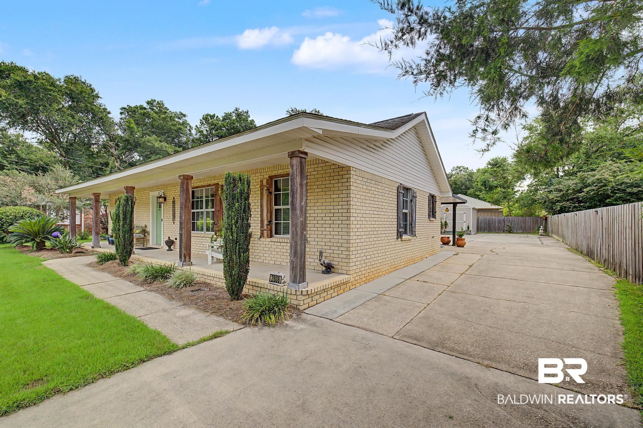 2808 Pine Ridge Drive Lillian, AL 36549 - Photo 3 of 47 Light-toned brick exterior with a covered front porch featuring rustic-style columns
