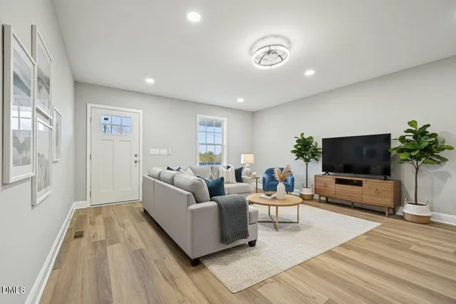 a view of kitchen with kitchen island a sink wooden floor and stainless steel appliances