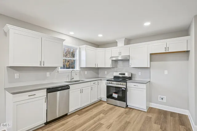 a kitchen with granite countertop white cabinets and white appliances