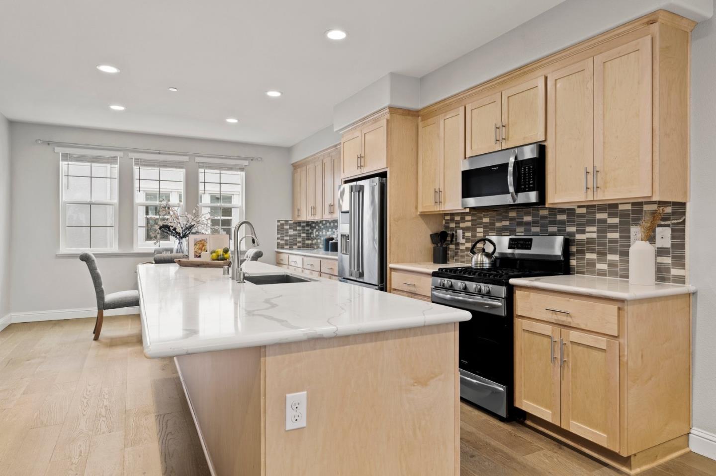 435 Montague Expressway Milpitas, CA 95035 - Photo 10 of 46 a kitchen with stainless steel appliances granite countertop a stove a sink a microwave a refrigerator a stove and white cabinets
