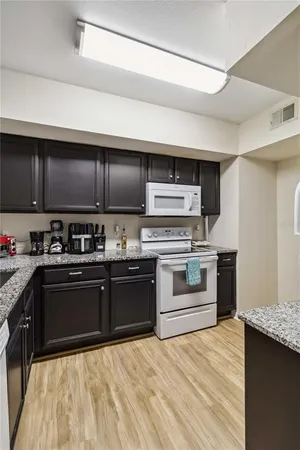 a kitchen with stainless steel appliances granite countertop a stove a sink and a microwave