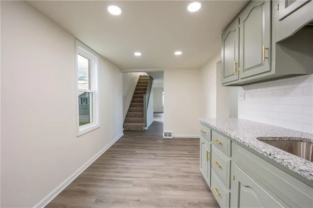 a view of a kitchen with wooden floor and staircase