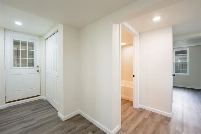 an empty room with wooden floor & windows