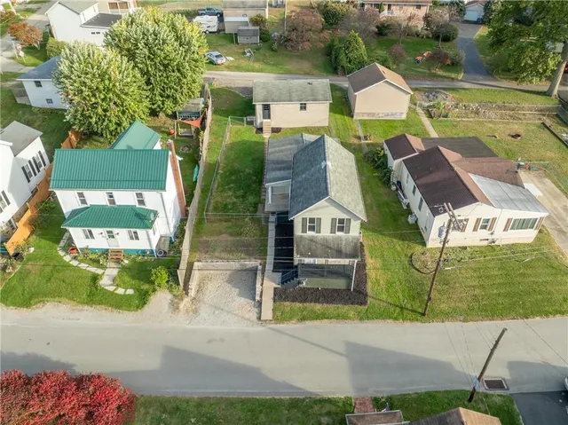 an aerial view of a house with a garden and lake view