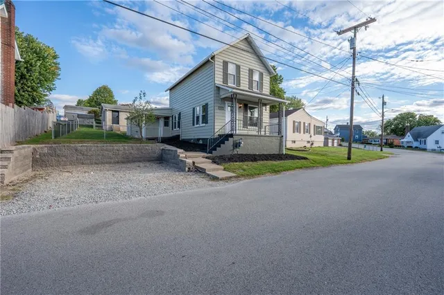 a view of a house with a yard and sitting area