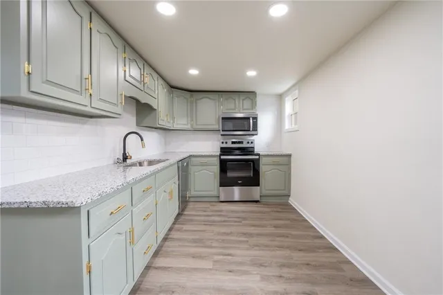 a large kitchen with stainless steel appliances granite countertop a sink and cabinets