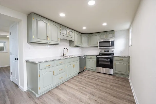 a kitchen with appliances a sink and cabinets