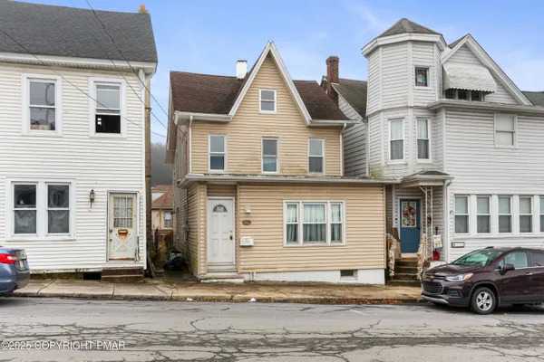 a front view of a house with a car parked in front of it