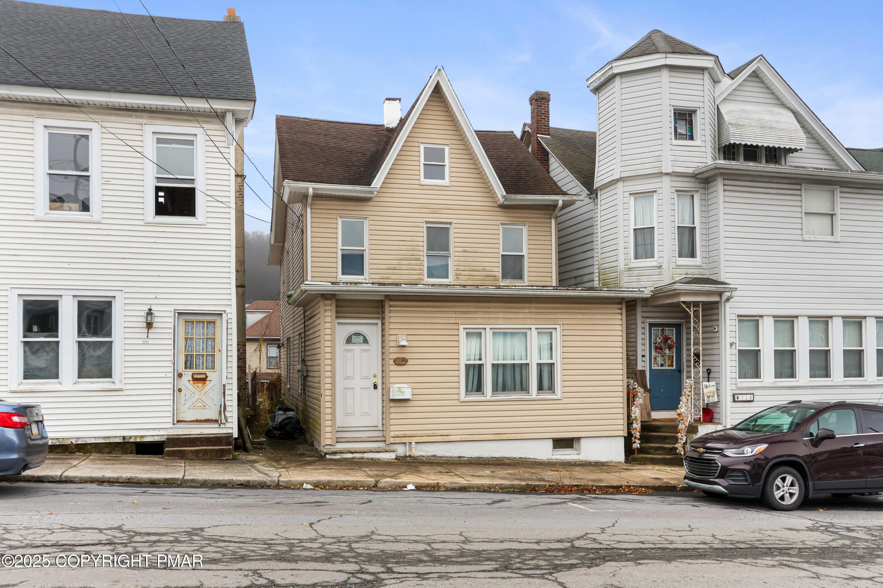a front view of a house with a car parked in front of it