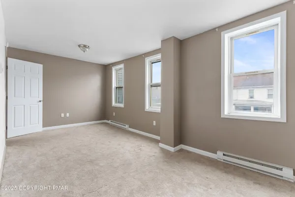 an empty room with windows and closet