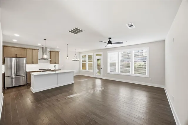 a view of kitchen with stainless steel appliances refrigerator stove microwave and cabinets