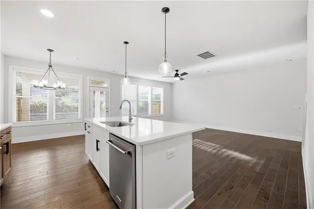 a kitchen with stainless steel appliances granite countertop a sink a window and chairs
