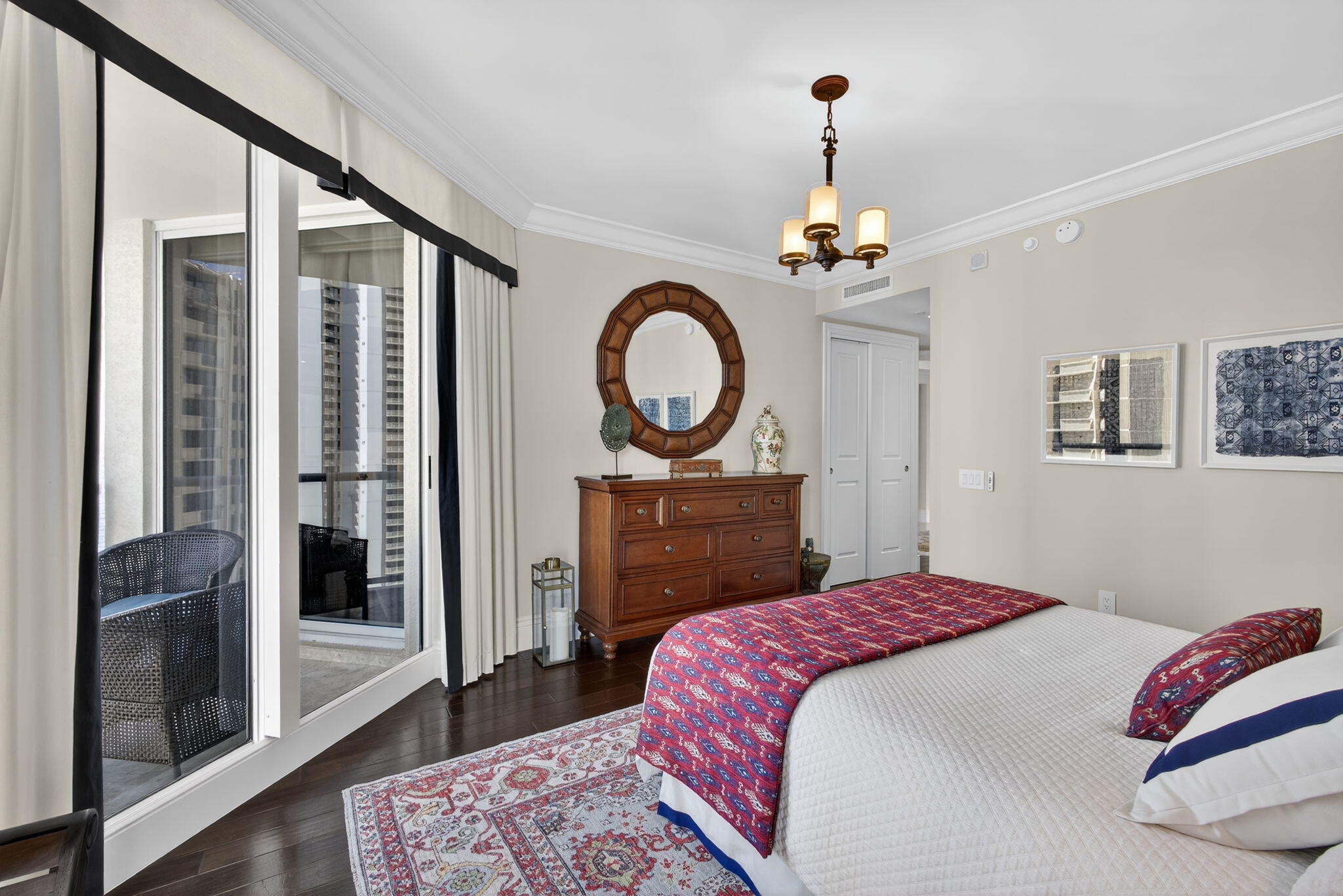 2700 North Ocean Drive, Unit 1401A Riviera Beach, FL 33404 - Photo 59 of 116 a bedroom with a bed a mirror and a chandelier
