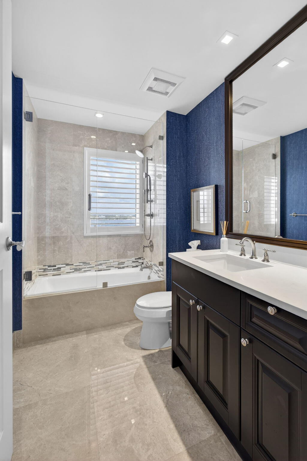 2700 North Ocean Drive, Unit 1401A Riviera Beach, FL 33404 - Photo 62 of 116 a bathroom with a granite countertop sink toilet mirror bathtub and next to a window