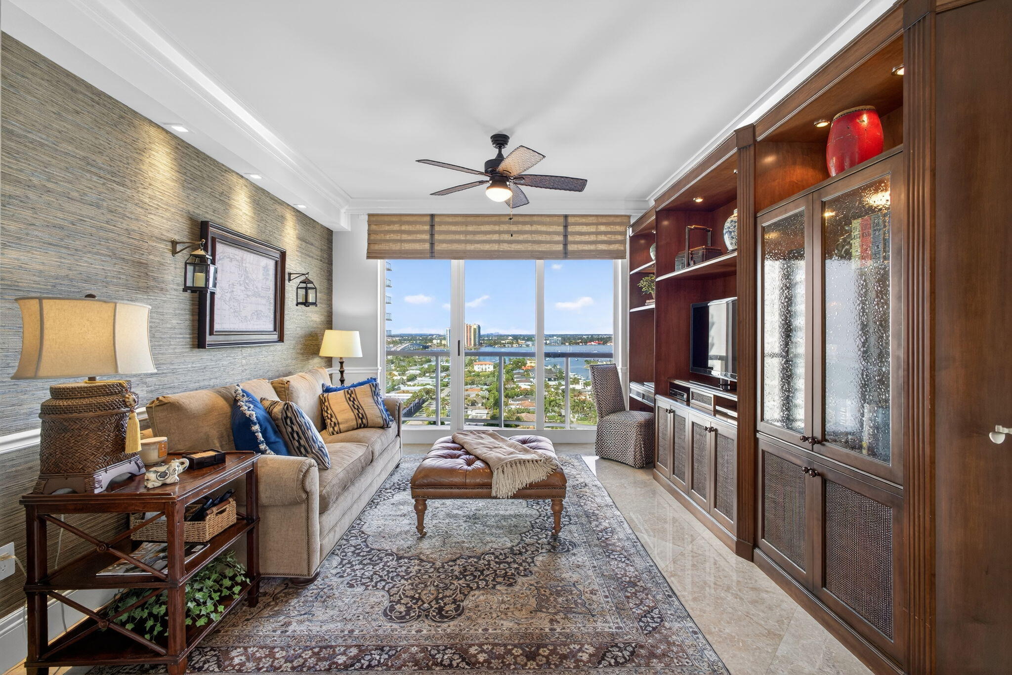 2700 North Ocean Drive, Unit 1401A Riviera Beach, FL 33404 - Photo 63 of 116 a living room with furniture a chandelier a large window and a flat screen tv