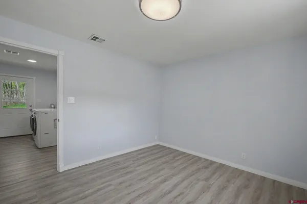 a view of empty room with wooden floor and window