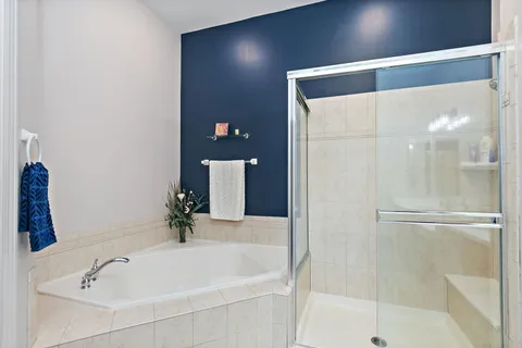 a white bath tub sitting next to a white sink and vanity