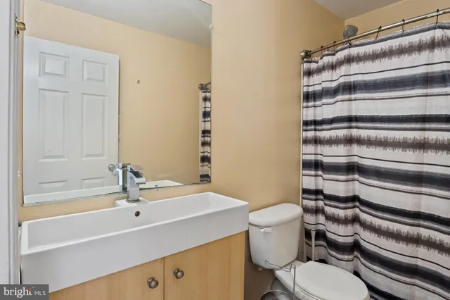 a white toilet sitting next to a bathroom sink and tub