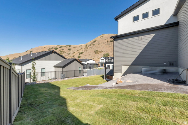 1711 West Canyon Rim Road North Lehi, UT 84048 - Photo 31 of 31 Expansive backyard featuring a green lawn, gravel-covered area, and privacy fencing