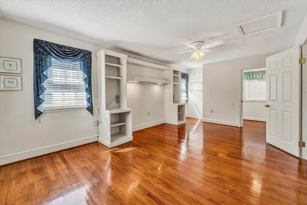 a kitchen with stainless steel appliances granite countertop a refrigerator and microwave with wooden floors
