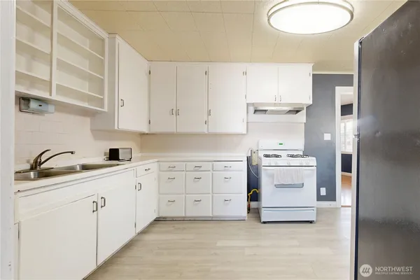 a kitchen with white cabinets and sink